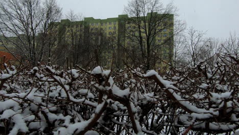 la nieve está cayendo en la ciudad, como se ve desde un pequeño patio de recreo en un suburbio de la ciudad