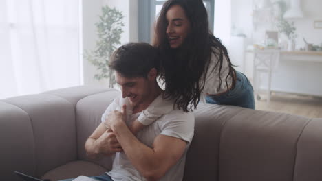 young woman giving massage to partner while working