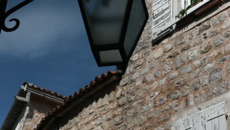 old stone building with lamppost and window