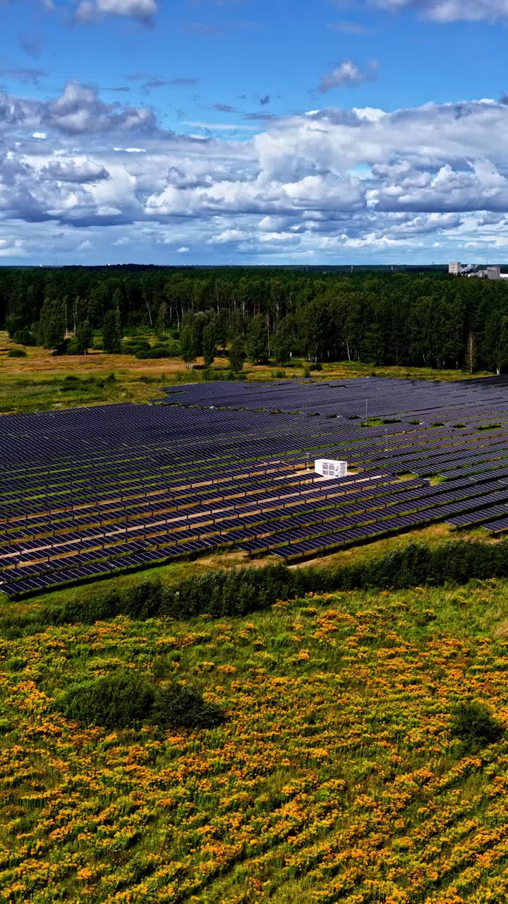Drone flight over a solar farm in a green zone amidst fields and forests