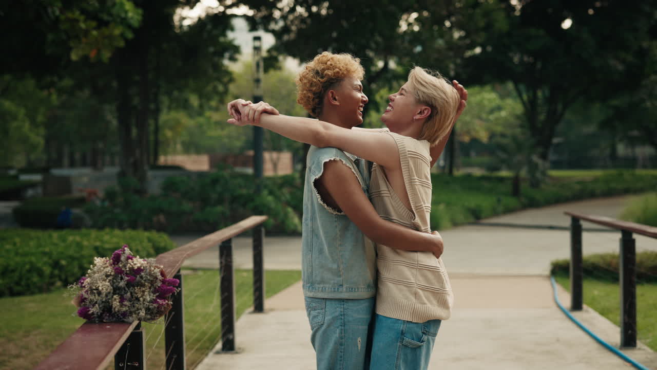 A lesbian couple embracing in a park