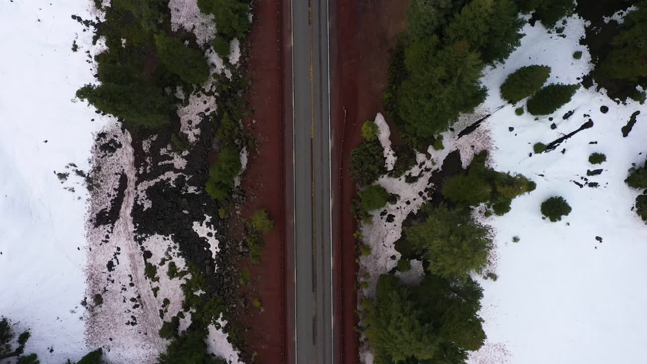 Vista dall'alto di un'autostrada di montagna dell'Oregon, con un'auto bianca che la percorre.