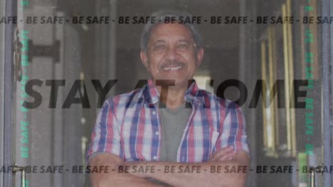 Animation-of-stay-at-home-be-safe-text-over-senior-man-smiling-at-home