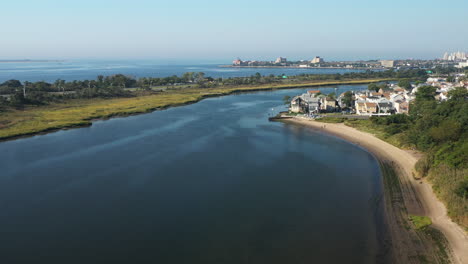 aerial drone dolly shot forward - descend over shell bank creek in brooklyn, ny toward an old, fat husky in the waters below