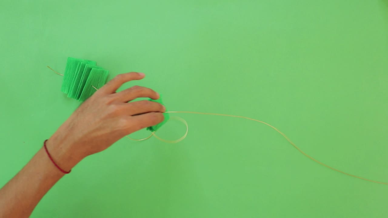 manos masculinas creando artesanías y decoraciones mexicanas hechas a mano en la mesa verde
