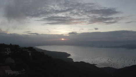 Dynamic-aerial-ascending-above-palm-trees-revealing-coast-sunset-Tagaytay