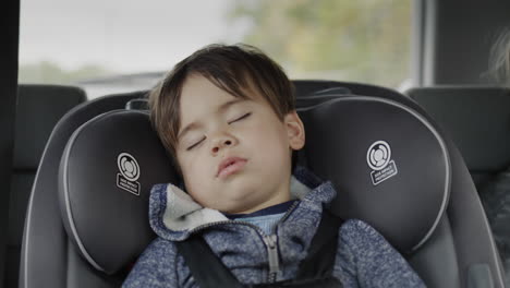 a los dos años, el niño viaja en un asiento de coche y duerme. viajando con niños