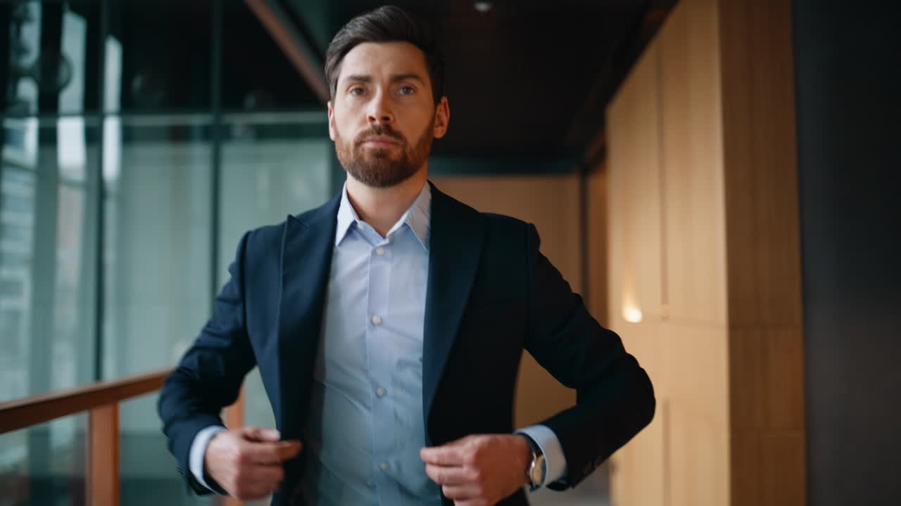 Wealthy man buttoning jacket walking modern office closeup. Elegant businessman