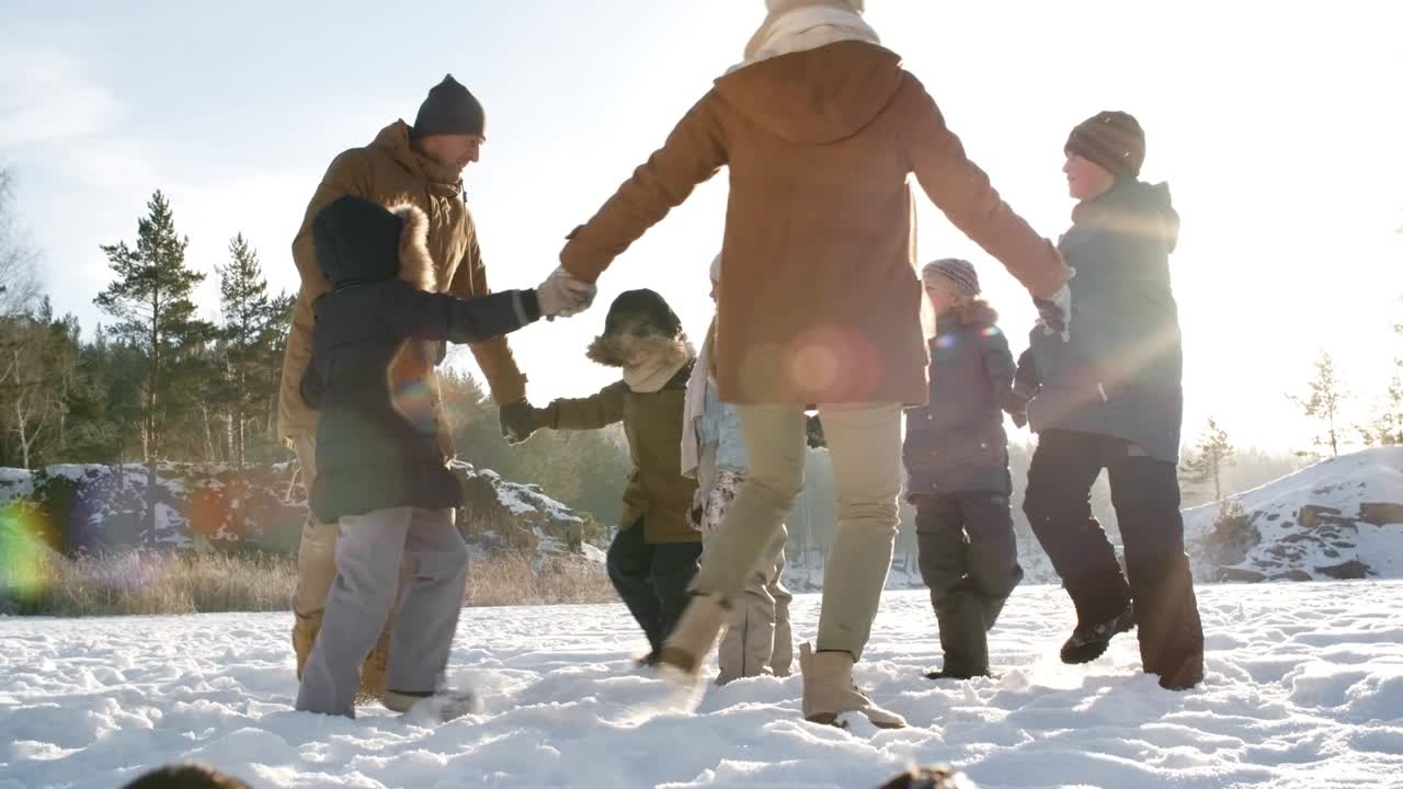 가족들이 눈 속에서 서클 댄스를 하고 있습니다.