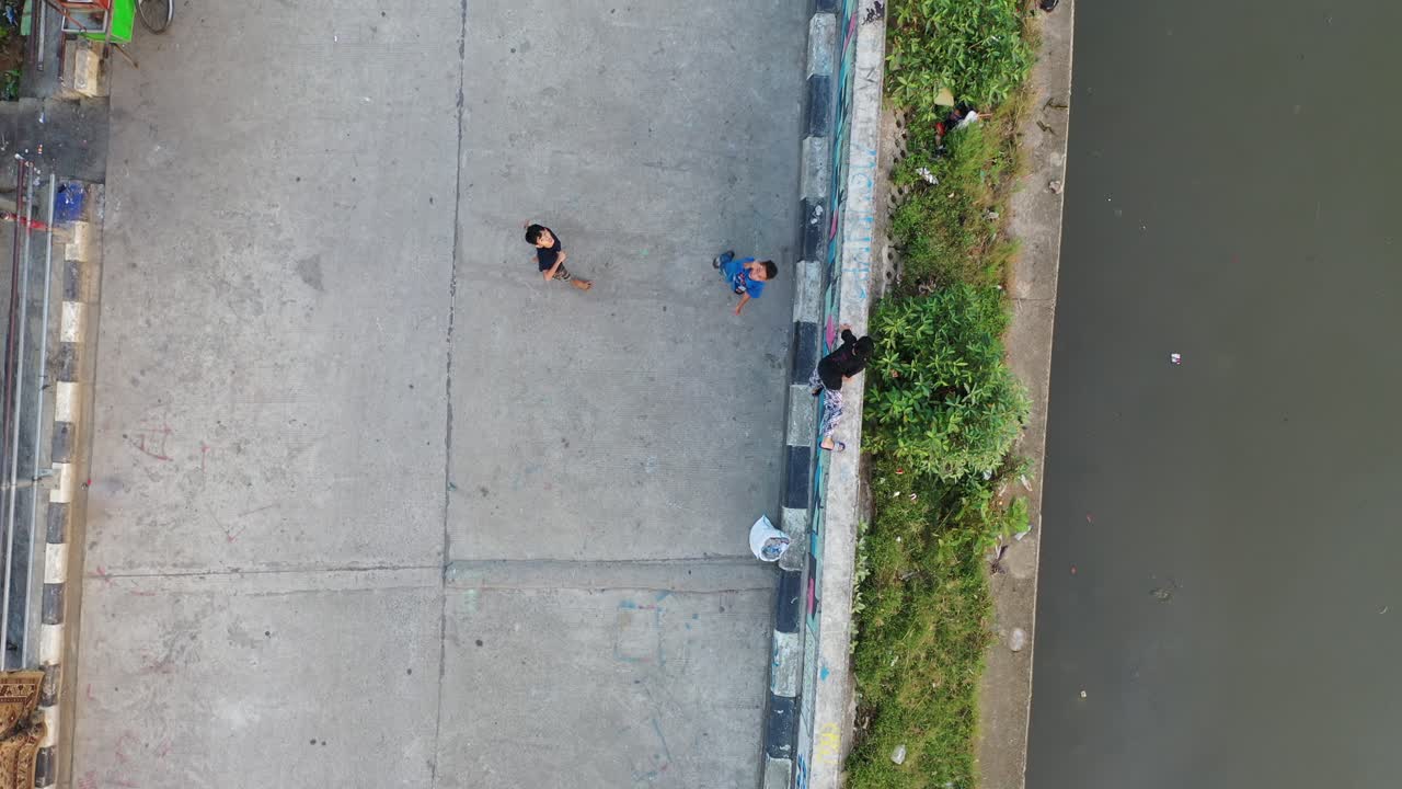 Children Playing on a Bridge Over a Canal in a City