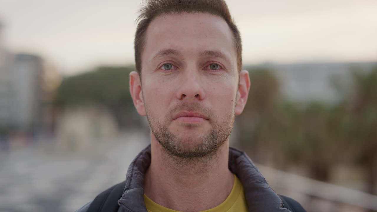 ritratto ravvicinato giovane uomo caucasico che cerca serio pensoso turista maschio che si gode una vacanza in città urbana al tramonto