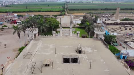 drone video flying forward on top of an abandoned castle in peru called "castillo unanue" green fields can be seen in the horizon