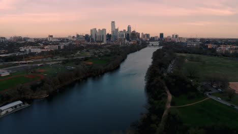 Drone-Aéreo-4k-Panorámico-Lento-Hacia-El-Centro-De-Austin,-El-Horizonte-De-Texas-Y-El-Lago-Ladybird-Al-Atardecer