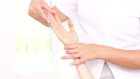 Physiotherapist-examining-her-patients-hand