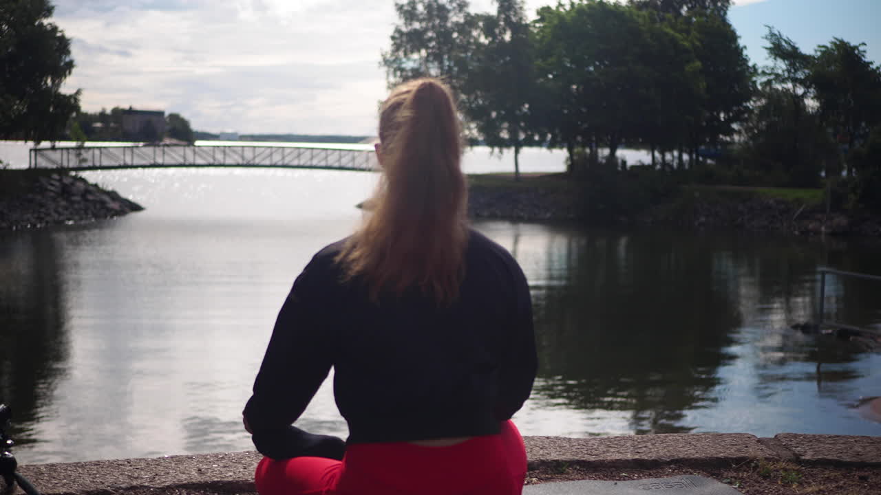 chica practicando yoga y meditación en posición de loto en la playa