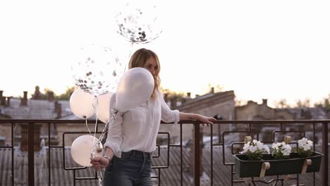 Blonde-Young-Women-In-White-Blouse-And-Jeans-Outside-On-The-Terrace-Or-Balcony