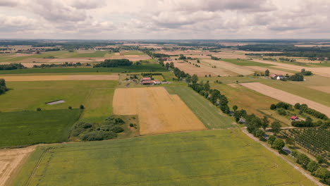 aerial of flat countryside in poland filled with farmland and various plots