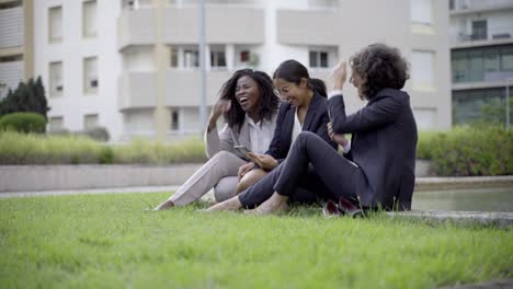 Alegres-Colegas-Femeninas-Descansando-Cerca-De-La-Piscina-Con-Un-Teléfono-Inteligente