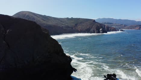 revealing shot of waves crashing on rocks