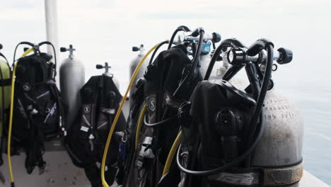 scuba tanks stand prepped for adventure against a backdrop of a cloudy ocean sky