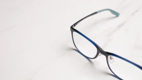 panning on a close-up of a pair of eyeglasses placed on top of a table