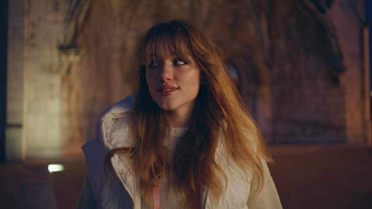 hermosa niña de pie calle de la noche en frente de la arquitectura medieval primer plano