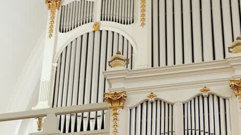 slow tracking view of pipe organ at front of old lutheran temple