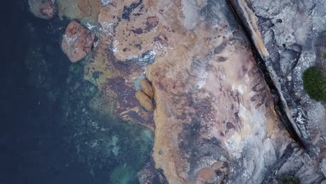 Aerial-View-Of-Waves-Splashing-On-Coastal-Rocks-In-Balmoral-Beach,-Sydney,-Australia---top-down-drone