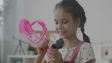 young girl painting a heart