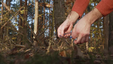 Glasses-lost-in-forest-and-found-on-ground,-crime-evidence-or-lucky-day-concept,-close-up-of-hands