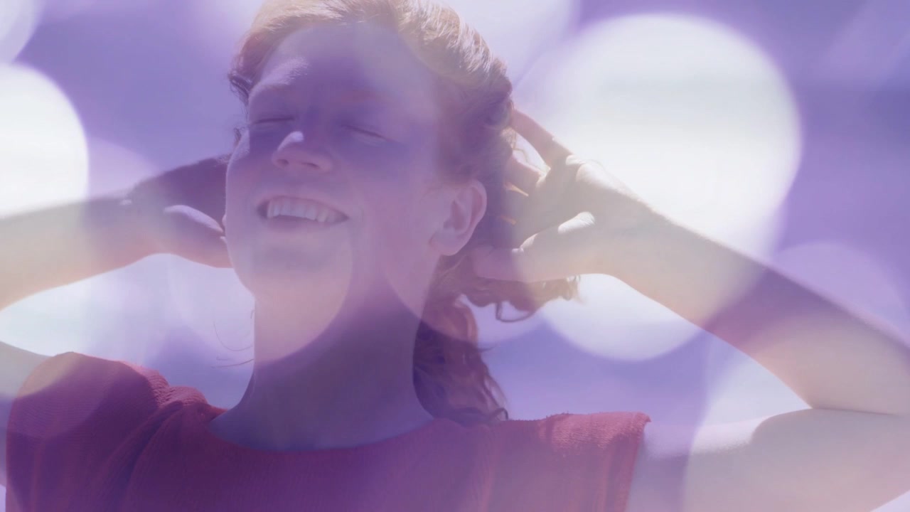 Fotogrammi in progressione, donna che si porta i palmi dietro la testa, sistemandosi i capelli per bellezza con bokeh viola.
