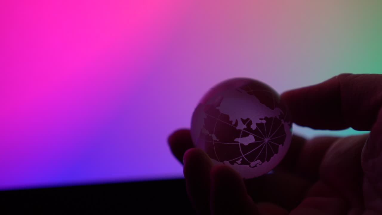tierra transparente en persona mano girando alrededor en fondo de color neón control abstracto