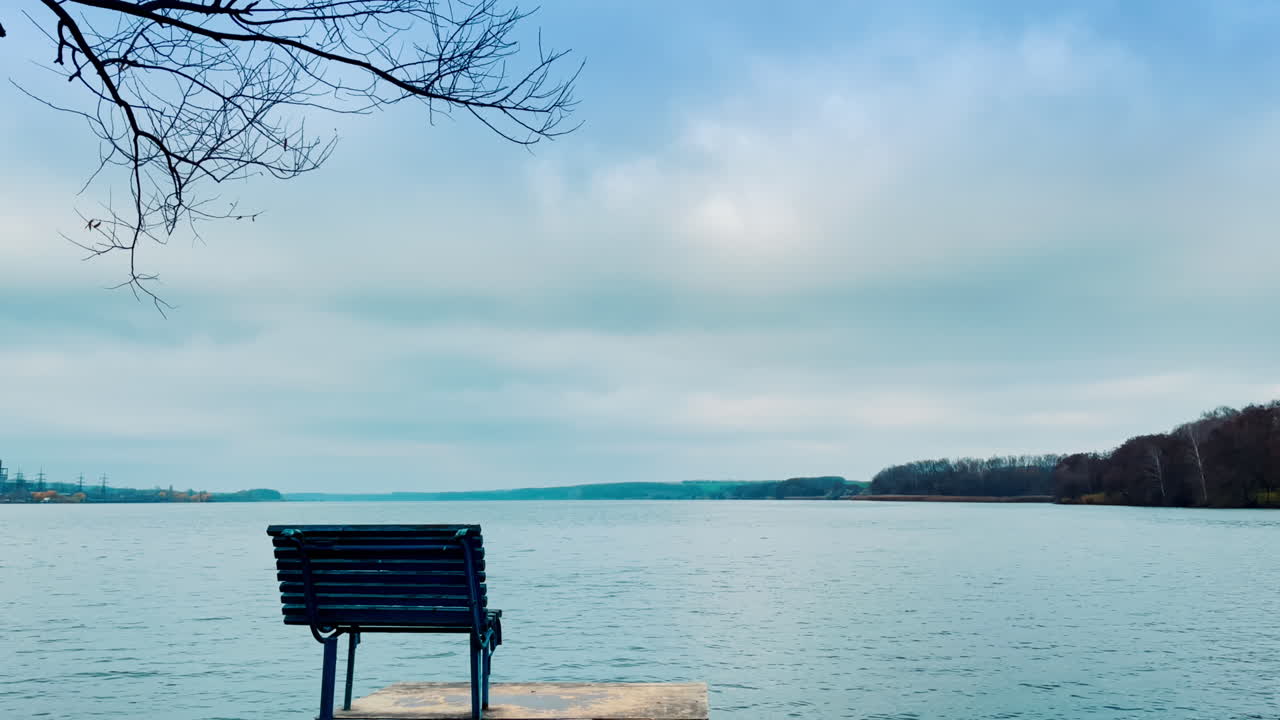 Empty Bench by the Lakeside on a Cloudy Day