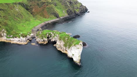 vista aérea de paralaje de impresionantes acantilados en una hermosa costa desde el castillo de kibane en irlanda del norte a lo largo de la carretera costera gigante durante un emocionante viaje por el país