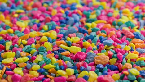 piedras de color trituradas en una superficie plana, girando lentamente, primer plano en bucle