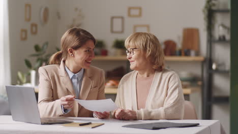 female financial agent consulting elderly woman at home