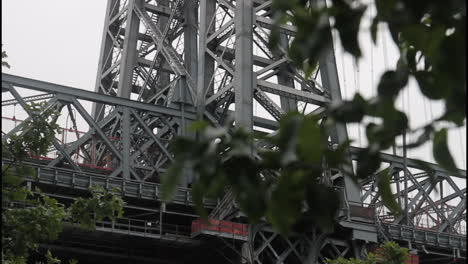 close-up view of a metal bridge structure with trees in the foreground