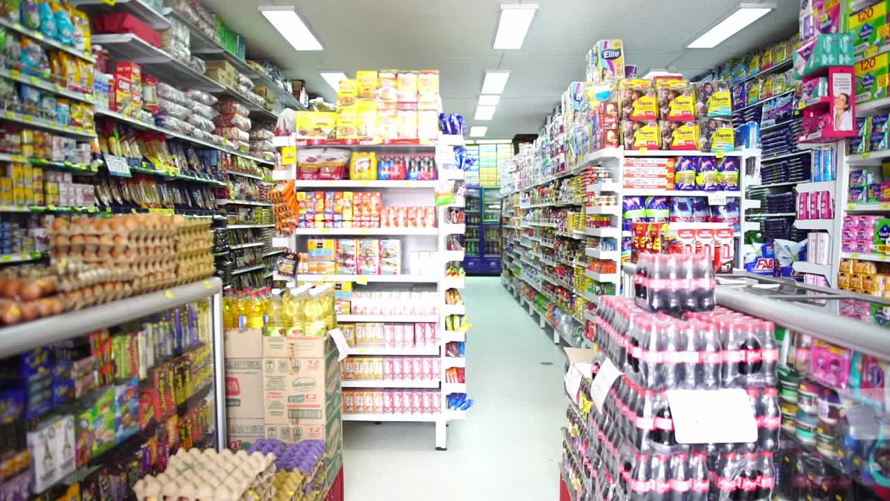 Fixed clip of full grocery store shelves, filled with brightly coloured products