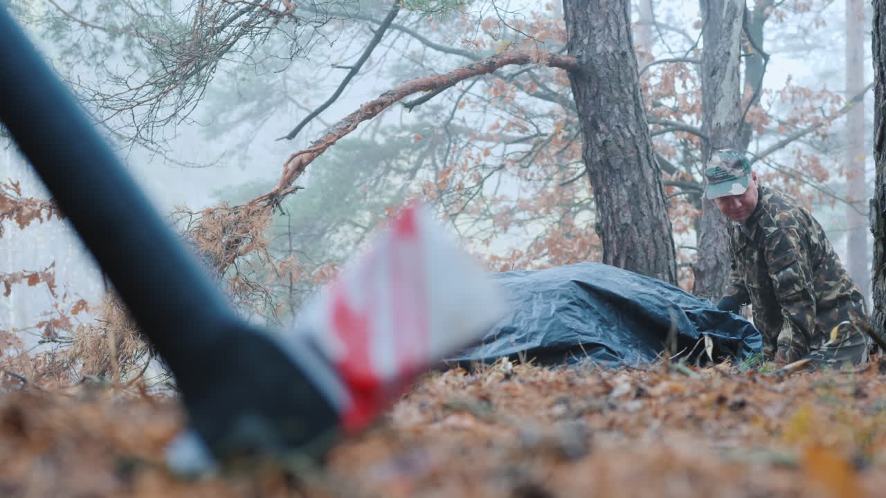 범죄자가 숲에서 피해자의 시체를 파다