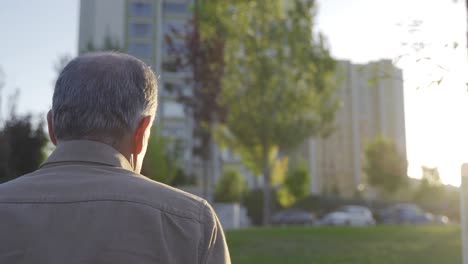 the old man is walking outdoors.