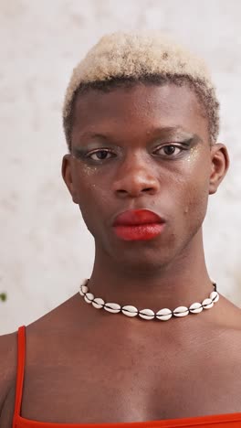 portrait of a person with dramatic glitter makeup and a shell necklace