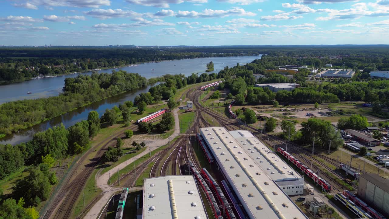 Hennigsdorf railway factory train depot overlooking the river in Brandenburg, Germany. Tremendous aerial view flight fly reverse overflight flyover drone