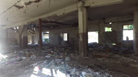 old abandoned ruin of ruined warehouse full of garbage and debris deserted after heavy weather rain or economic crisis with collapsed roof ceiling and walls