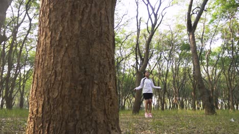 hermosa mujer atlética ejercicios con salto, saltando la cuerda en el bosque