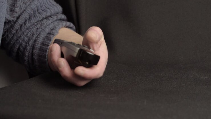 Hand using remote control to change channel close up shot