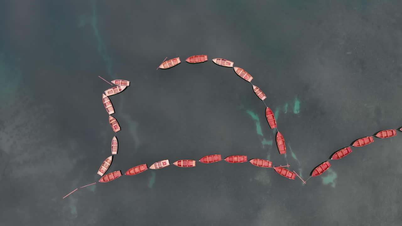 이탈리아 백운석에 있는 브라이에스 호수에 정렬된 보트 위로 무인기에서 공중 수직 폐쇄 샷