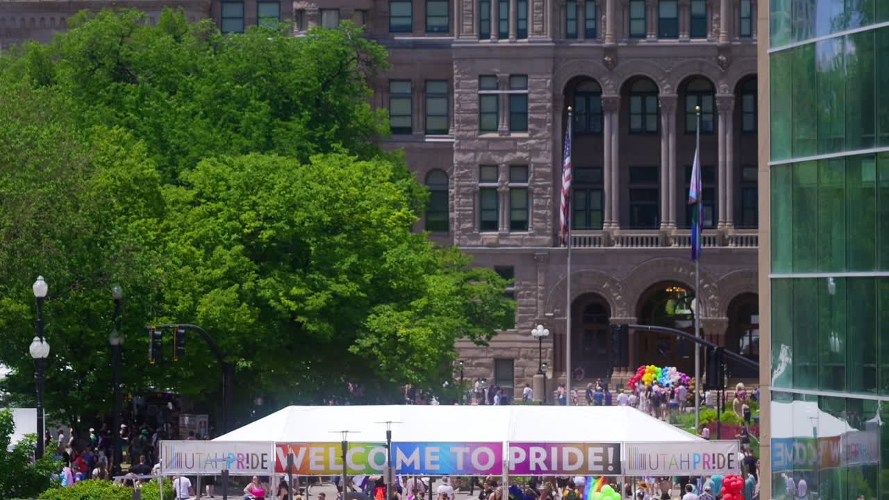Large Welcome To Pride - Utah Pride banner at entrance as camera pans up to the clock tower on the Salt Lake City County Building during the 2024 gay pride parade event at the Salt Lake City Library
