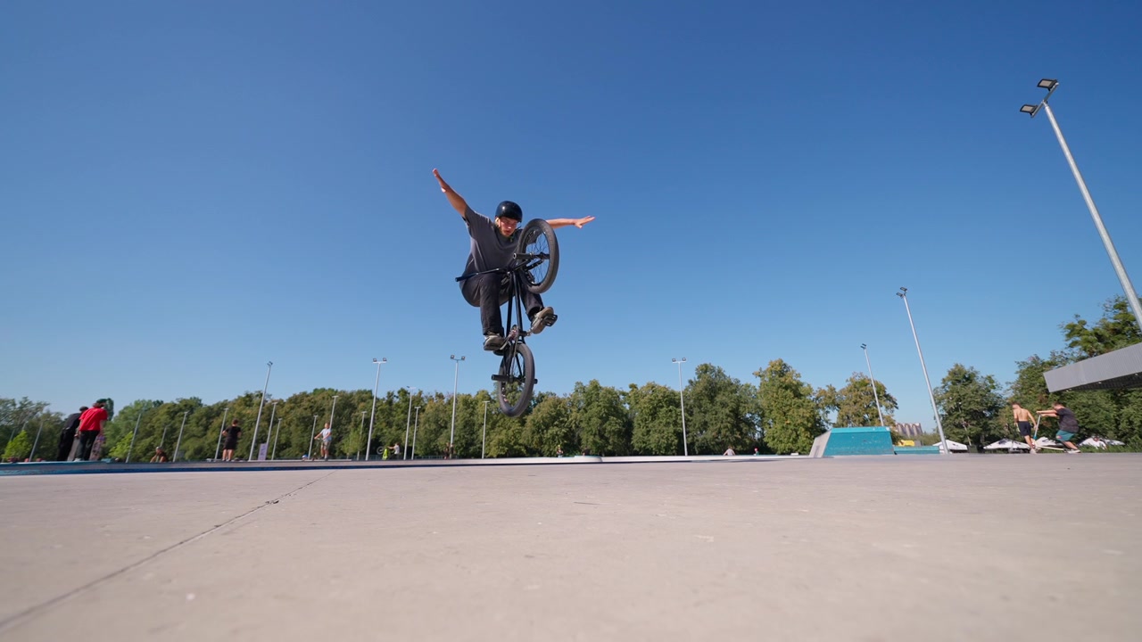 Giovane uomo che esegue un trick di BMX Flatland in uno skatepark