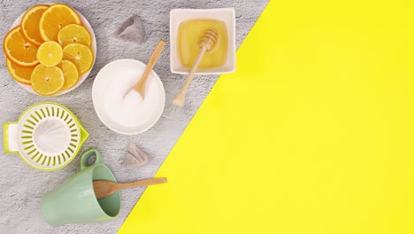 sliced lemons and supplies for making tea appear on left aide of yellow theme. stop motion