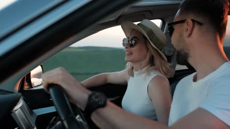 happy young couple sitting inside their car and enjoying road trip, travel and adventure concept